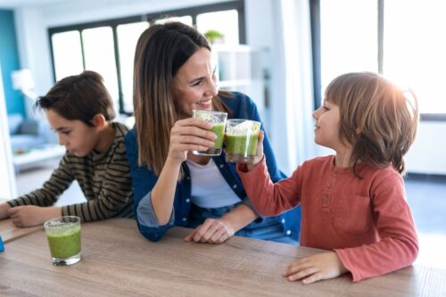 women's nutrition-young-mother-with-her-son-drinking-green-smoothie