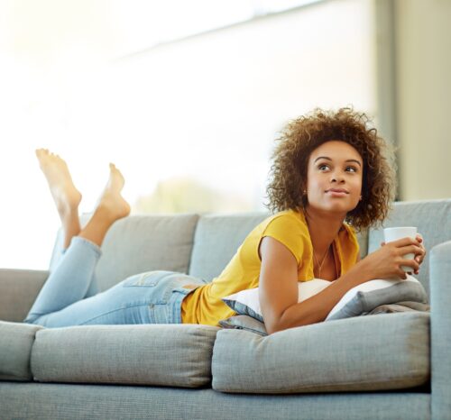 woman resting on the couch to curb period cravings