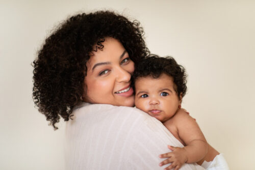 Woman snuggles new baby over her shoulder