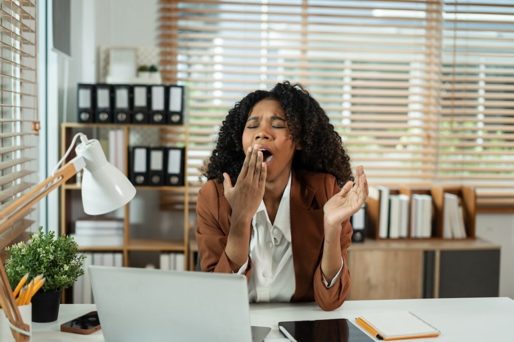 tired woman trying to stay awake at work