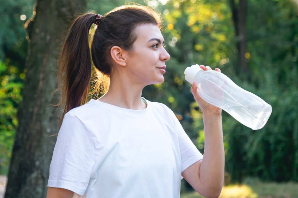 woman drinking water on hot summer day